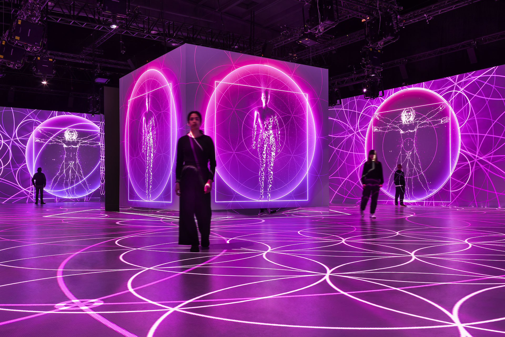 People standing amidst a vibrant immersive experience.