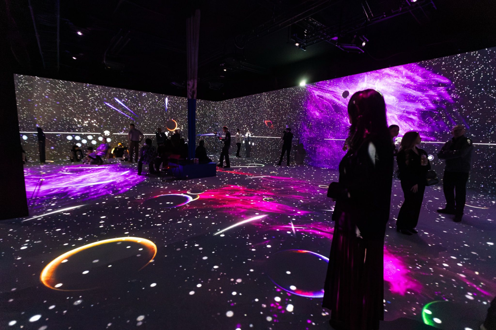 A vivid purple and pink cosmic projection filling a gallery room